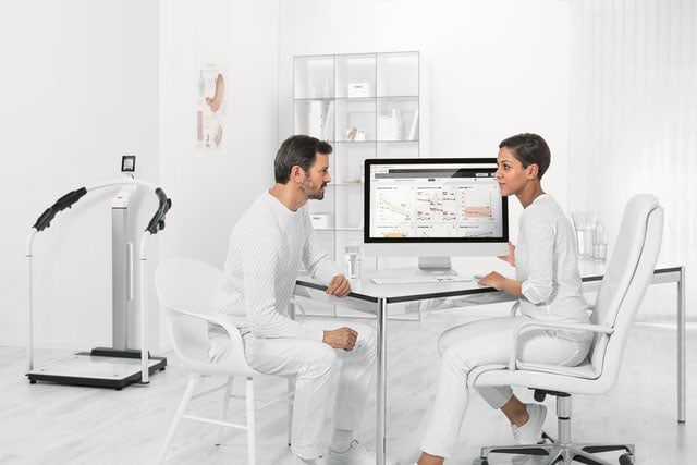 Doctor and patient in conversation during physiotherapy and digital analysis.