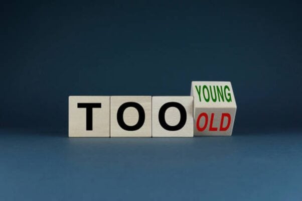 Spielzeugwürfel mit "TOO" und "YOUNG" sowie "OLD" für Altersfragen.