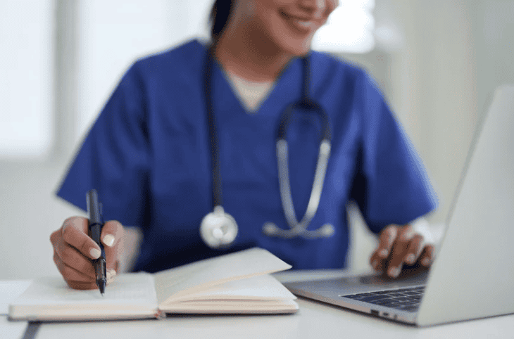 Medical specialist with laptop and notebook